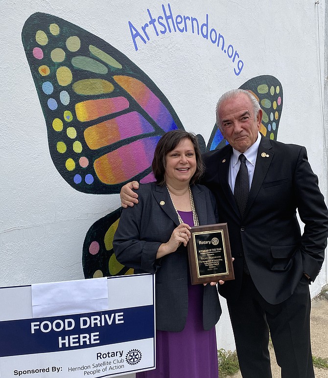 Signe Friedrichs, Herndon Rotary Club’s Rotarian of the Year 2020-2021, and chair of the Satellite Club of Herndon Rotary, joins Rudy Tassara, past president of the Club at ArtsHerndon for a photo. The site was one of the many that the Satellite Club established during the pandemic as a donation drop-off.