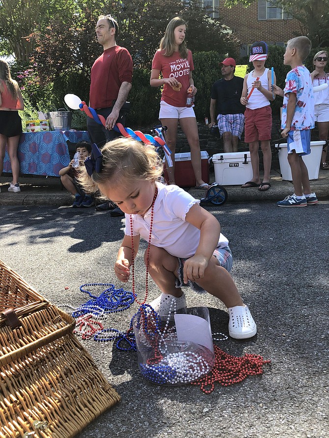 Elle Ferguson, 20 months old, had a job to do as the older people around her caught up with each other: removing and replacing beaded necklaces.