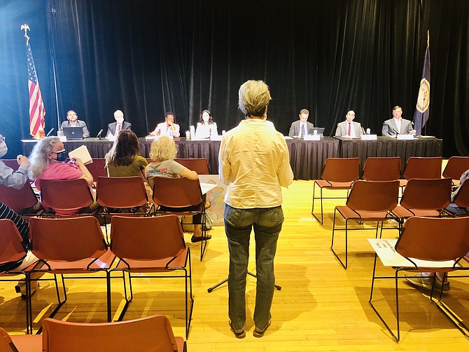 Members of the redistricting commission listen to Debora Wake, president of the League of Women Voters of Virginia, during a public hearing this week at George Mason University.