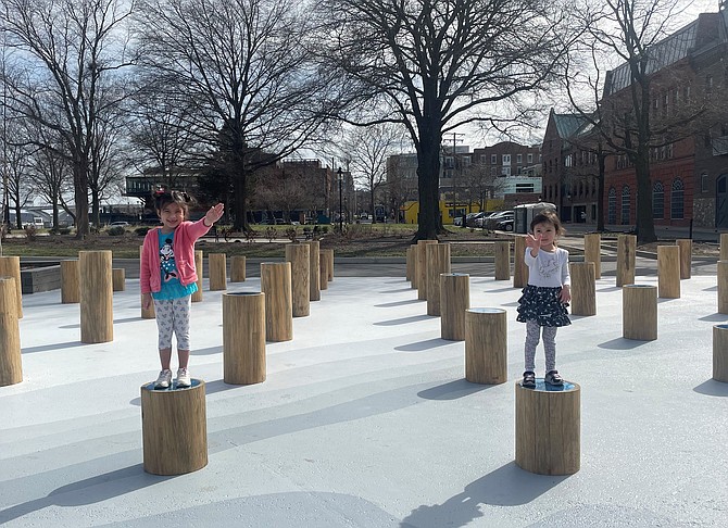 Sisters Victoria and Azura Ungureanu play atop pillars in “Groundswell,” the public art installation at Waterfront Park in Old Town. The temporary display runs through Nov. 1