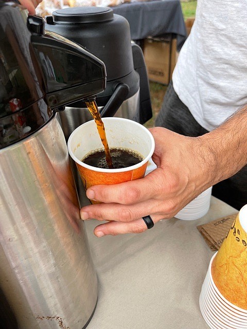 Leo Maggio pours a cup of the Ethiopian “Motivation,” a customer favorite at the Arlington Farmers Market located at Dorothy Hamm Middle School