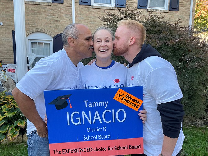 School Board District B candidate Tammy Ignacio, center, gets a victory kiss from husband Victor Ignacio, left, and son Dillion Ignacio Nov. 3 outside their Alexandria home.