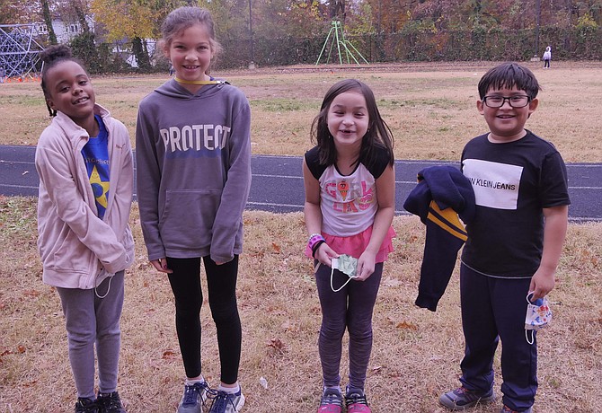 Randolph Elementary students shiver outside as they pose for a picture without masks November 22. They share Thanksgiving plans. Left to right:  Makayla Simpson, Louisa Weekend, Ella Jessup, Steven Martinez Molina.