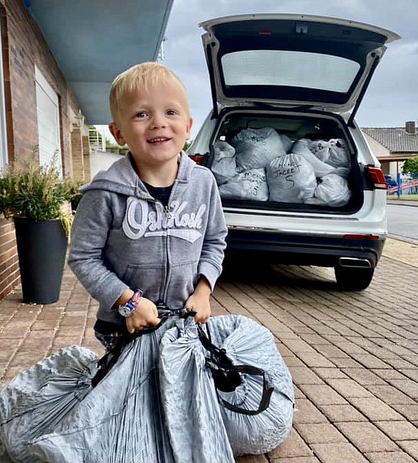 Three year old Jackson Wise helps pack and load jackets and other warm clothing donated by friends and neighbors of his family for evacuees traveling through Germany.