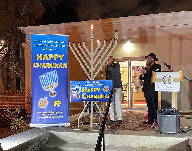 Mayor Justin Wilson lights the shamash or service candle of the Grand Menorah to begin the celebration of Hanukkah Nov. 28 at the Lyceum as Rabbi Mordechai Newman looks on.