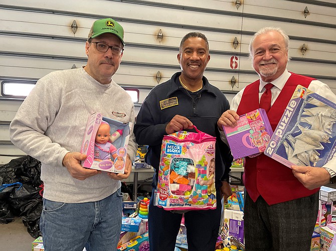 Firefighters and Friends founder Willie Bailey, center, with volunteers Bruce Witucki and Al Chadsey at the annual toy distribution day Dec. 10 at Penn Daw Fire Station 11.