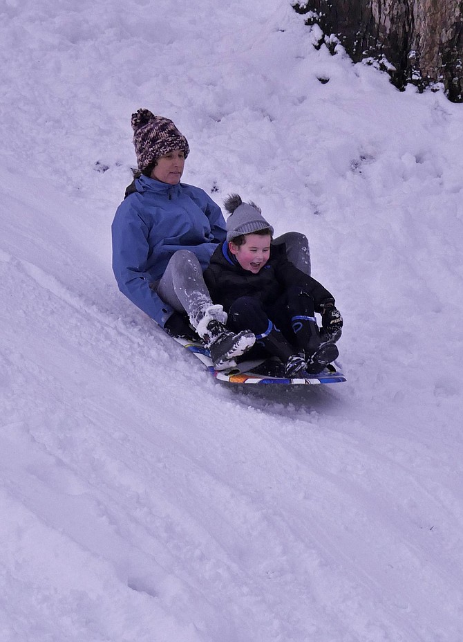 Josh Hennessy-Davis and his mother try out sledding the hill in front of their house in Arlington where they had recently moved from Australia where they’d never seen snow like this.