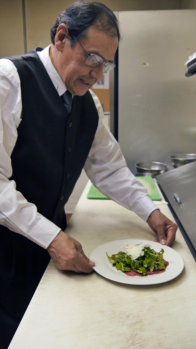 Long-time Café Oggi chef Orlando Quiroga prepares his last carpaccio on New Year’s Eve.