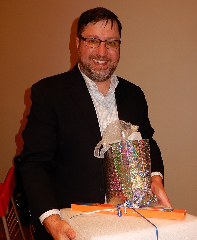Eliot Goldberg holding thank-you gifts for his work on the eruv committee.