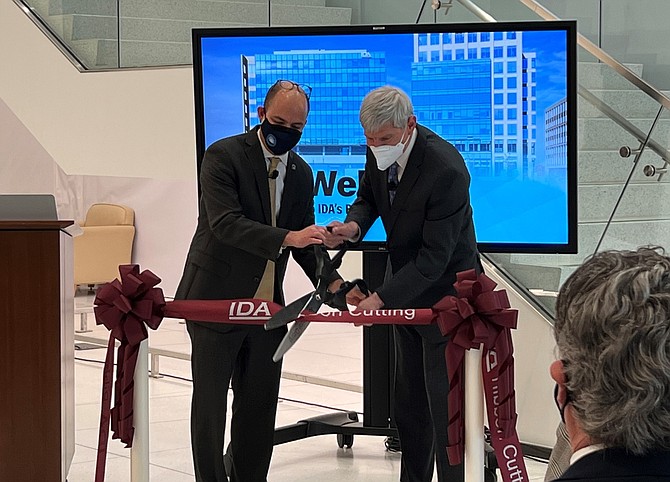 Mayor Justin Wilson, left, joins Institute for Defense Analyses President Norty Schwartz in cutting the ribbon celebrating the opening of the new IDA headquarters Jan. 25 in Potomac Yard.