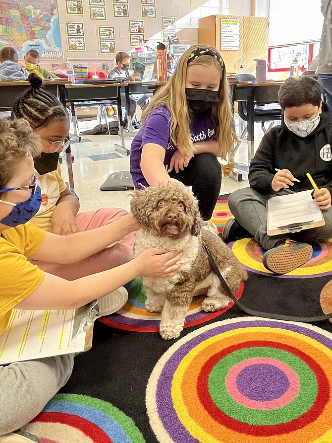 From left, Benjamin Silvernail, Mya Wilson, Khloe Gozdieski, and Jason Lemus with Nike the therapy dog at Aldrin Elementary in Reston.