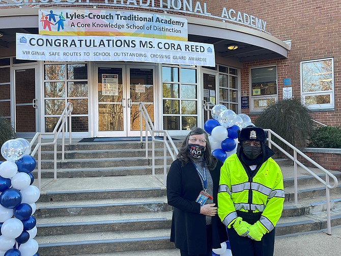 Cora Reed, right, is congratulated by Lyles-Crouch Traditional Academy principal Patricia Zissios on her recognition as one of the five Most Outstanding Crossing Guards in Virginia.