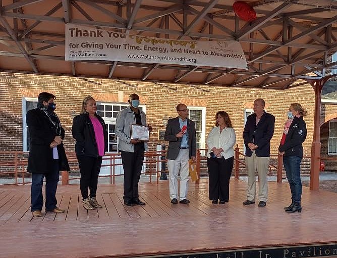 Mayor Justin Wilson, center, is joined by Volunteer Alexandria executive director Marion Brunken, right, at the announcement of the organization’s annual Volunteers are the Heart of Alexandria awards Feb. 15 at Market Square.