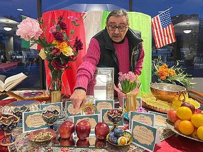 Kambiz Behbahani points to objects signifying the first day of spring during a traditional Nowruz celebration of the Persian New Year March 12 at the Watergate of Landmark.