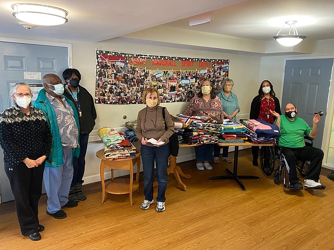 Members of McLean Quilters Unlimited display quilts that members donated to Mary Marshall Assisted Living