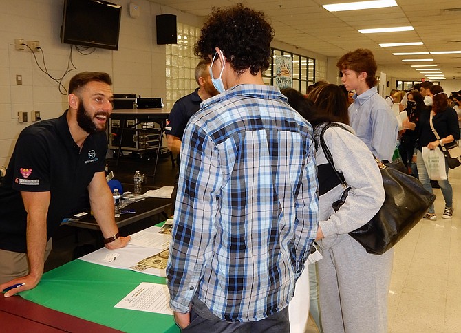 At far left, Daniil Gomenyuk of DreamHome eagerly tells students what his company has to offer.