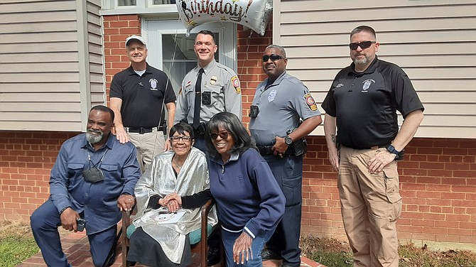 Ada Singletary is joined by Pastor Darrell K. White, left, Queenie Cox, right and Officer Kevin Shaw, Detective Daryl Davis and others from the Mount Vernon station.