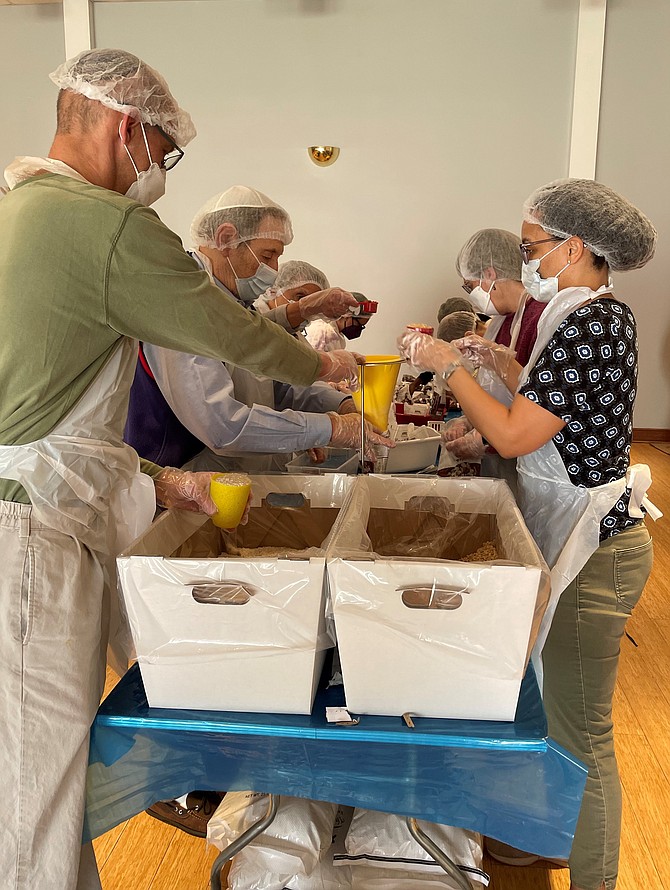 More than 20,000 meals to combat hunger are assembled by volunteers from Agudas Achim Congregation and Alfred Street Baptist Church as part of Good Deeds Day April 3.