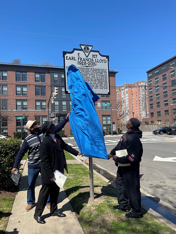 Earl Lloyd nephews Reginald Lloyd, left, and Cornelius Lloyd, right, are joined by Derek Lymus in unveiling the historic marker at Lloyd’s childhood home April 2 on Montgomery Street. Lloyd was the first African American to break the color barrier in the NBA in 1950.