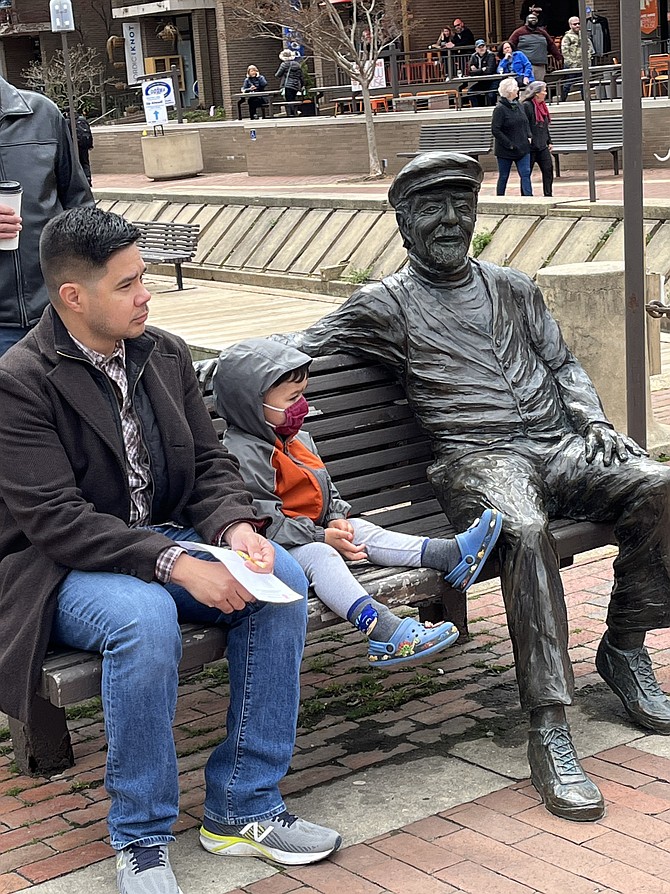 Taking a seat next to “Bronze Bob.” In 2004, the bronze statue of Robert Edward Simon Jr. was erected at Washington Plaza at Lake Anne, Reston.