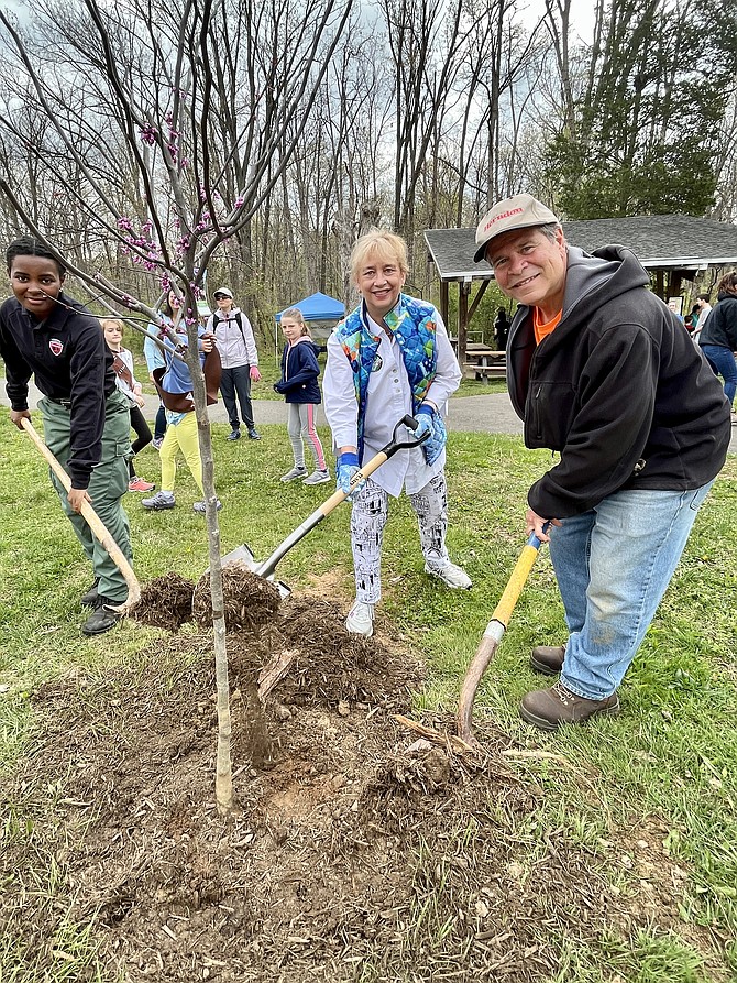 (From left) Lindsey Long, community forest specialist with the Virginia Department of Forestry, Sheila Olem, mayor of the Town of Herndon, and John Dudzinsky, community forester of the Town of Herndon, plant an Eastern Redbud, prized for its purple-pink blossoms, as part of the town's Arbor Day 2022 celebration.