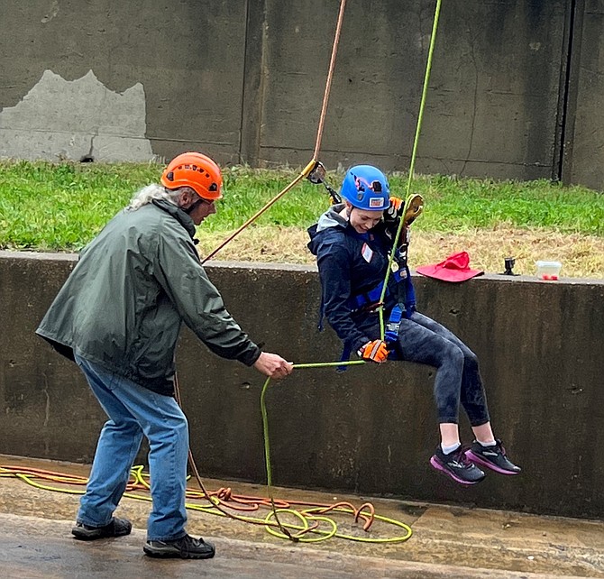 Emily Shepherd of McLean-based Clearsight Advisors prepares to touch down after rappelling down 14 stories of the Crystal City Hilton May 6 as part of a fundraiser for New Hope Housing.