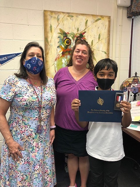 Orange Hunt E.S. winner Manaf Rahman with his teacher Ms. Simonsen and Orange Hunt principal Ms. Tuttle.