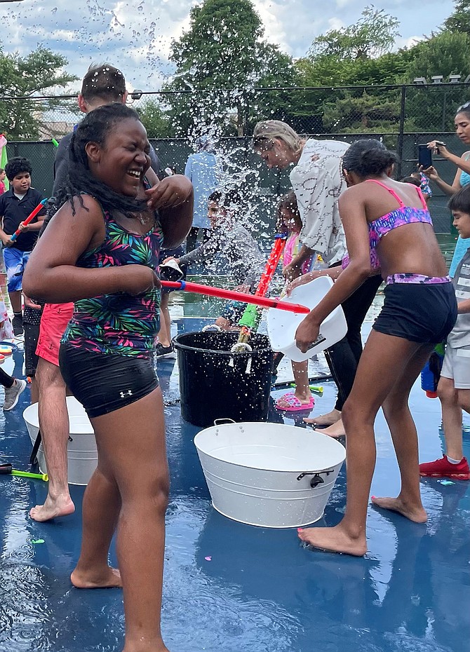A resident of Watergate at Landmark gets soaked during the June 10 water fight welcoming summer. Photo by Janet Barnett/Gazette Packet