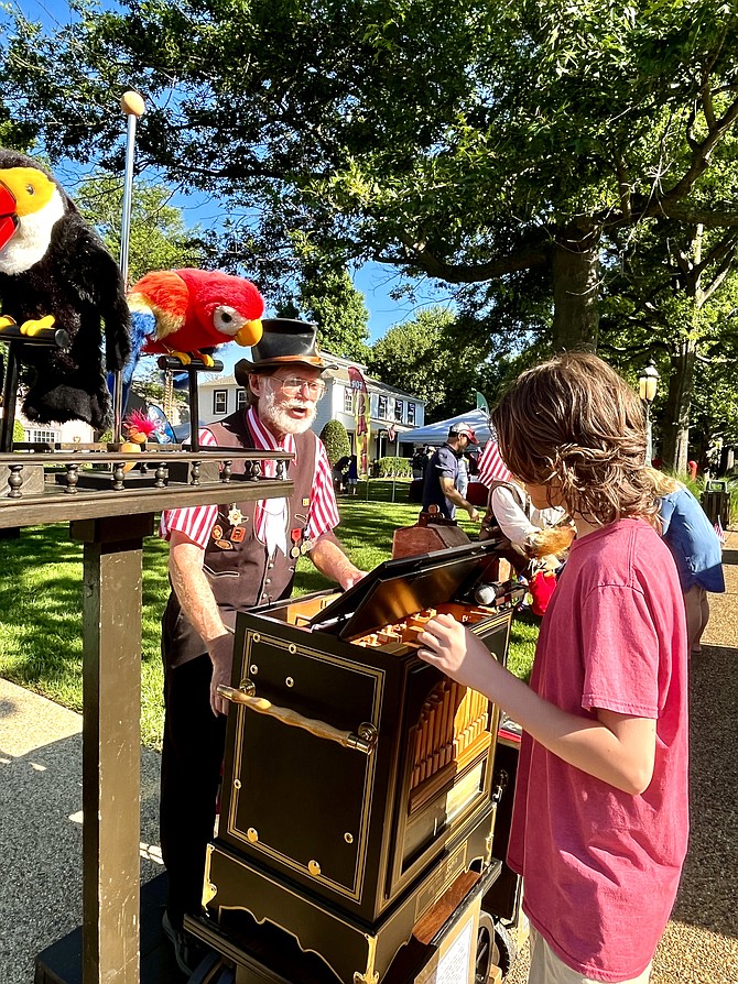 Volunteer Azure Briguglio, 12, of Great Falls, checks out Terry Bender, the organ grinder.