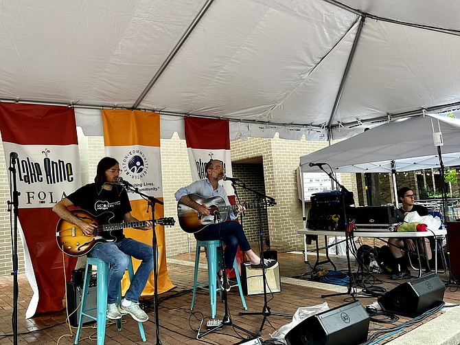With summer Saturday soggy, the Ronney family from Reston, Wen, Nick, and their baby, know exactly where to go so the good times roll. The 2022 Roots Festival at Lake Anne Plaza in Reston brings that community feeling and chill'n to the music.