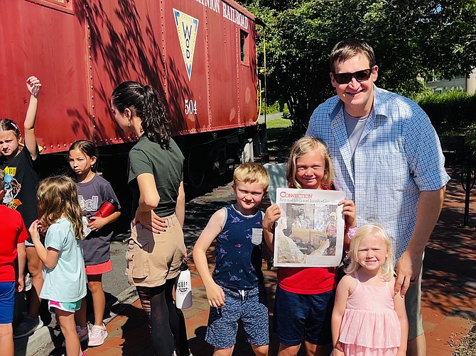 The Hoffmann family of Herndon (far right) wait in line to go inside the Red Caboose after visiting the Farmers Market and before walking over to the Town's Farmers Market Fun Days.