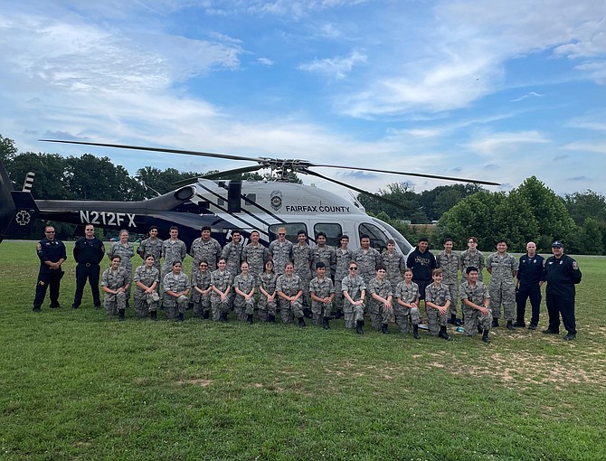 Members of the Burke Composite Squadron of the Civil Air Patrol pose with the crew of Fairfax One July 7 at Washington Irving Middle School.