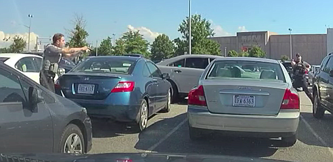 Fairfax County police officers with guns drawn approaching Christian Parker in his car.