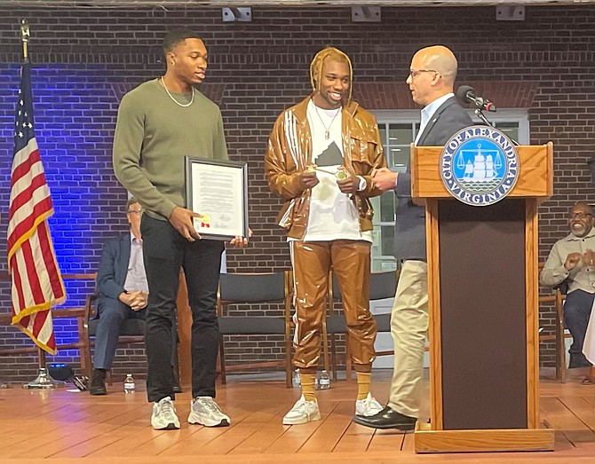 Mayor Justin Wilson, right, presents a proclamation and keys to the city to brothers Josephus and Noah Lyles on Oct. 10 in Market Square.