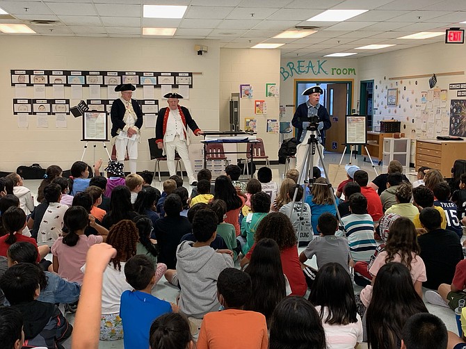 From left, Dave Cook, Larry McKinley and Jeff Thomas, all of the Fairfax Resolves Chapter of the Sons of the American Revolution, give a presentation to students at Bull Run Elementary.