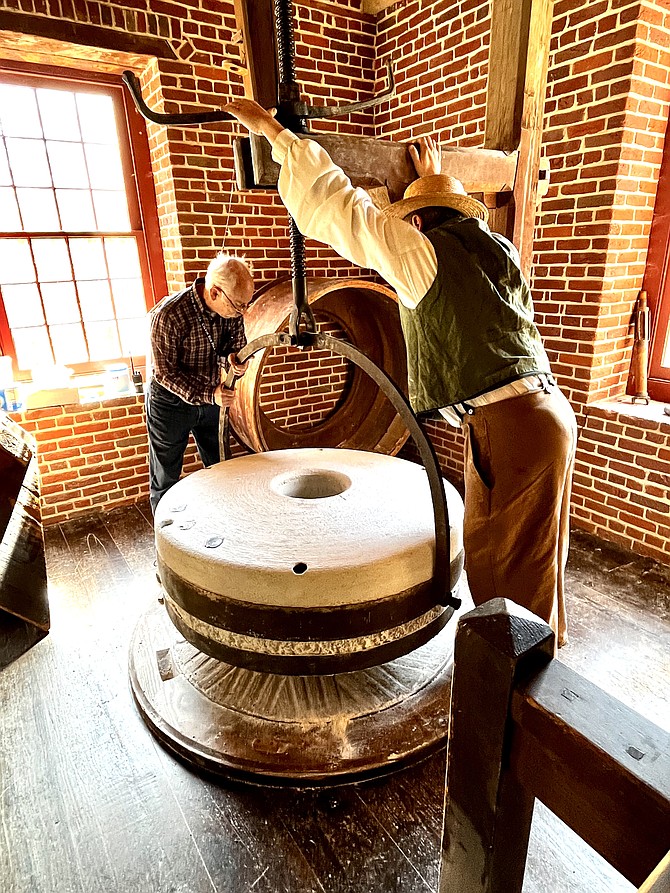 (Right) Steve Golobic, miller at Colvin Run, and volunteer Bob Coblerz of Springfield set the millstones in place during Harvest Time at Colvin Run Mill.