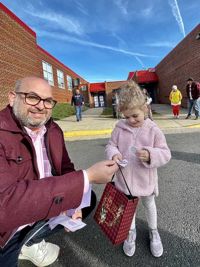 A little future voter gets an I Love Herndon sticker from candidate Keven LeBlanc running in the Town of Herndon election for councilmember.