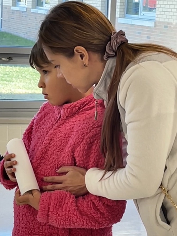 A young girl is embraced as she waits to place her remembrance candle for Helen Bahta Oukubazghi at a day of remembrance organized by Northern Virginia Families for Safe Streets.
https://novasafestreets.org/