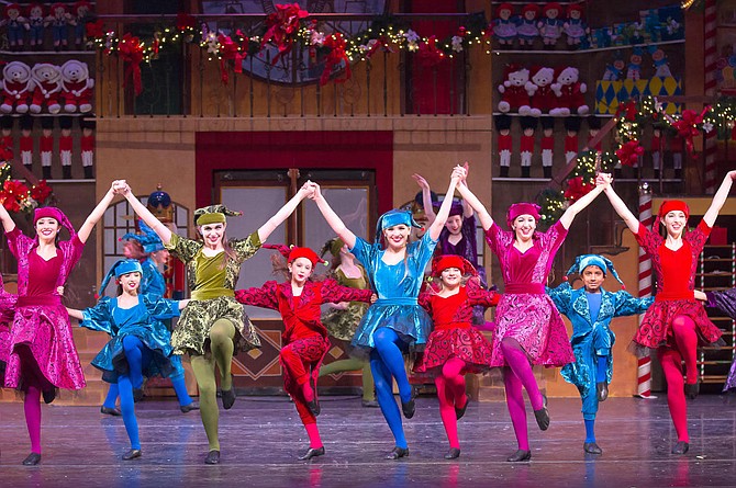 Colorful elves fill the stage during a dance number.