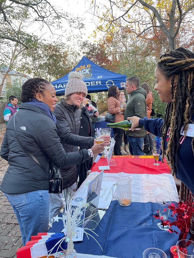Angelique Moss, right, of the Alexandria-Caen Sister Cities Committee, serves Valdela Chevre Cidre Fermier to guests at the Cider Festival Nov. 19 at Lloyd House.