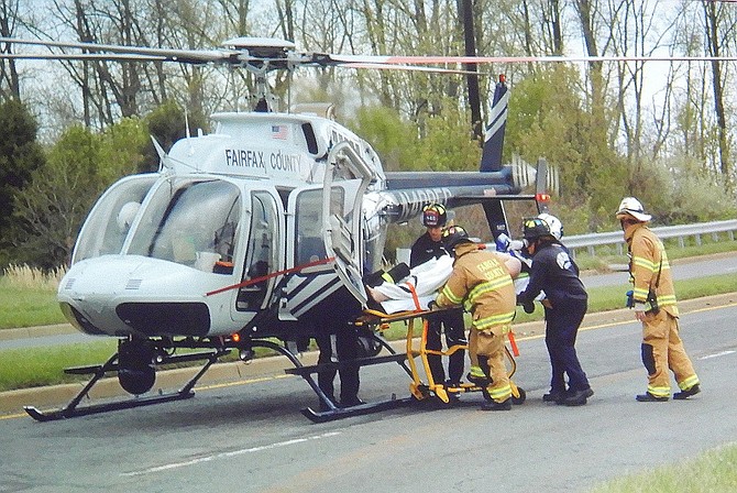 Police and firefighters place a patient inside the helicopter.