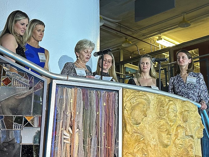 Eva Donley, surrounded by her daughters, speaks about her late husband Kerry’s support for the Center for Alexandria’s Children at the CAC gala Jan. 28 at the Torpedo Factory Art Center.