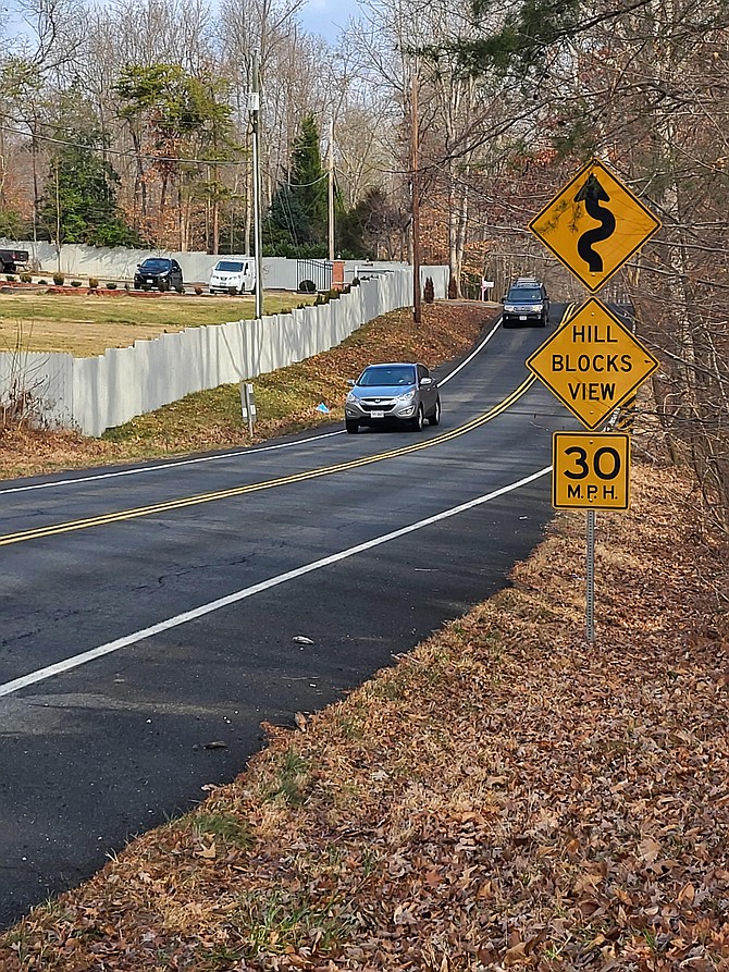 Right before the hill, a resident’s fence goes right up to the road.