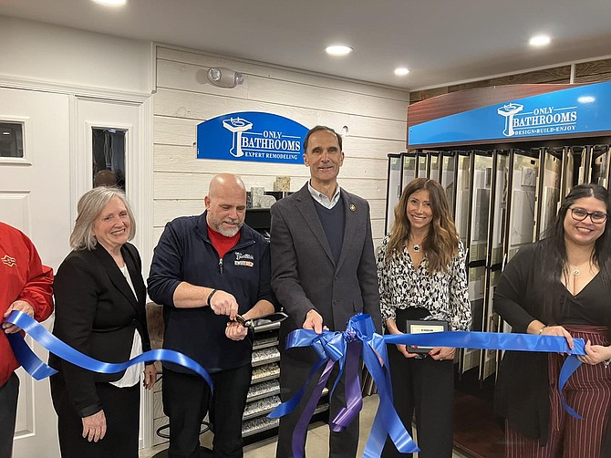 Larry Newman, center, and Supervisor Dan Storck, cut the ribbon to open the new Only Bathrooms showroom on Sherwood Hall Lane.