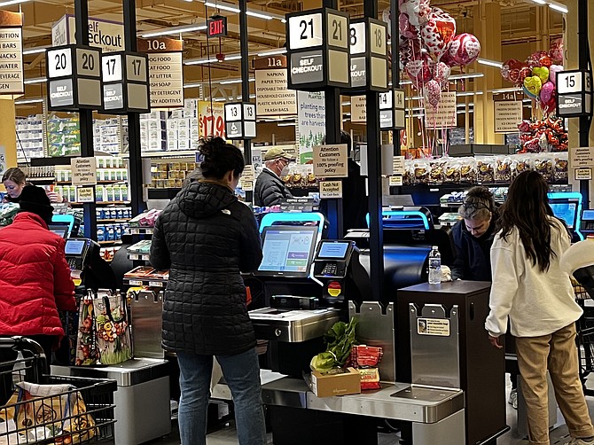 Shoppers use the self-checkout.