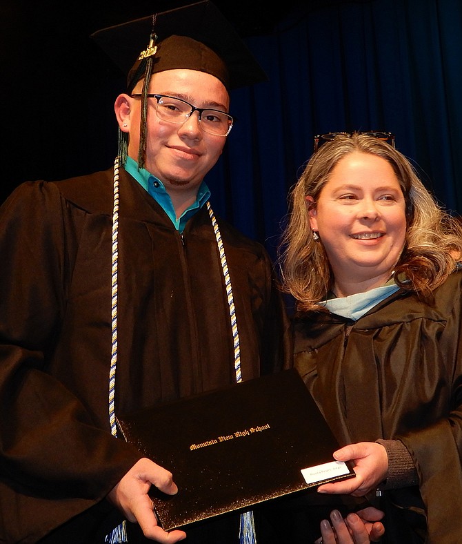 Student speaker Jorge “Ricky” Reyes receives his diploma from Catherine Stone.