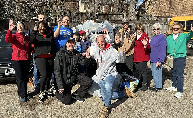 Frank Fannon, kneeling center, poses for a photo with volunteers and supporters of the 15th annual Alexandrians Have Heart food and clothing drive Feb. 11 at the South Henry Street Coal Yard.