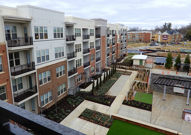 A partial view from a second-floor balcony, showing condo exteriors and gardens in the courtyard.