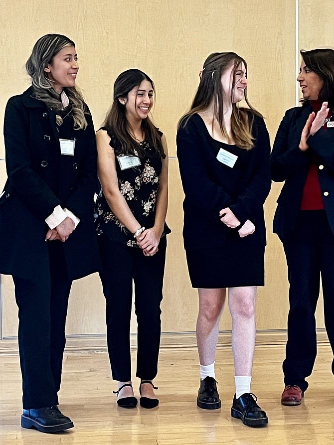 School Board Chair Rachna Sizemore Heizer congratulates students who are members of Girls Up at Justice High School.