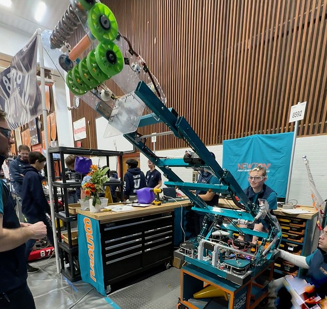 Newton2 of Fairfax team member Reba-Grace Lee operates the robots arm in the pit in preparation for the next competition run.